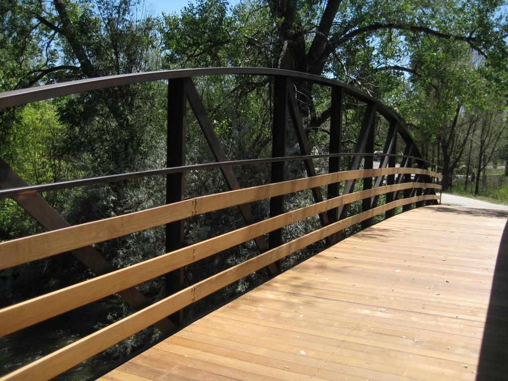 Steel and wood bridge creek crossing on the Clear Creek Greenbelt in Wheat Ridge, Colorado