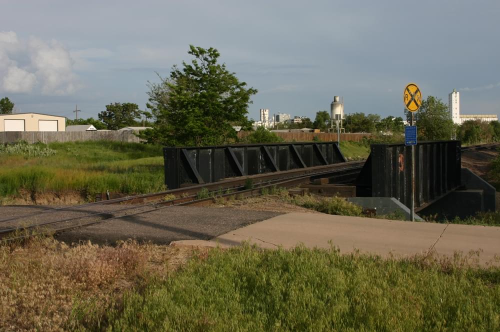 Asphalt paving at rail crossing on concrete trail that provides access to Platte River Greenway; Commerce City, Colorado