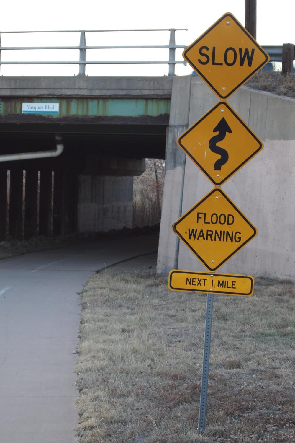 Watch for possible flooding over the next mile, as well as general caution signs; Sand Creek Greenway, Commerce City, Colorado