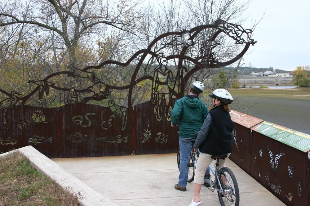 Cut steel sculptural fence interprets natural features along Quad Cities RiverWay at Arsenal Island.