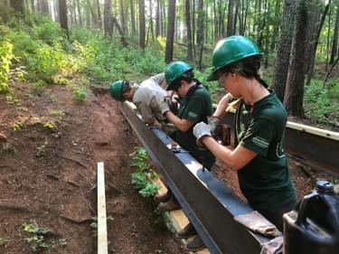 Members of Texas Conservation Corps' Trails Across Texas Program addressed erosion and drainage issues by building several bridges on the Whispering Pines Trail at Bastrop State Park. - Credit: American YouthWorks