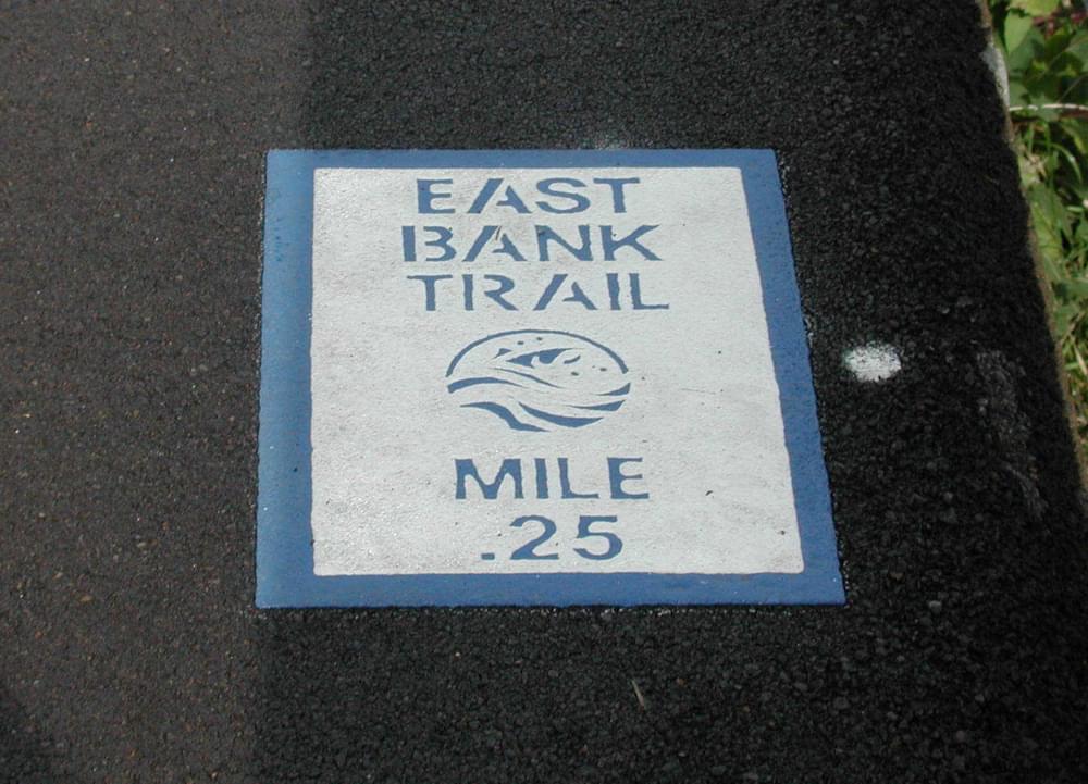 Mile marker applied to the asphalt trail surface of the Willamette River Greenway; Eugene, Oregon