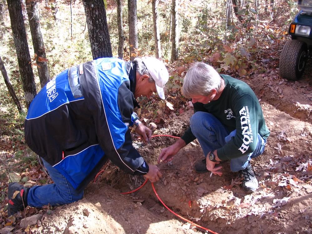 Members of the Cheaha Trail Riders installing traffic counters on one of the OHV trails in Minooka Park near Jemison, Alabama