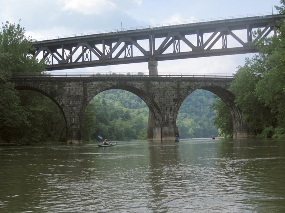 Paddlers look up at two generations of railroad bridges as they canoe the Conemaugh River in Pennsylvania