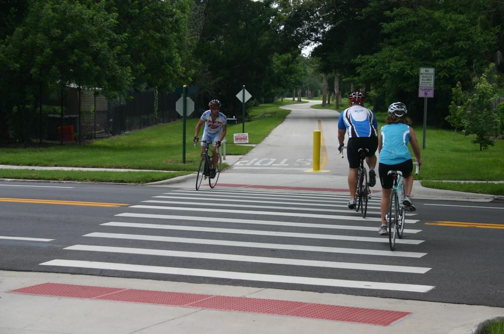 Street crossing includes a tactile warning strip for blind trail users, but bollard is a hazard to bikers as well as the sight impaired; Orlando's Cady Way Trail