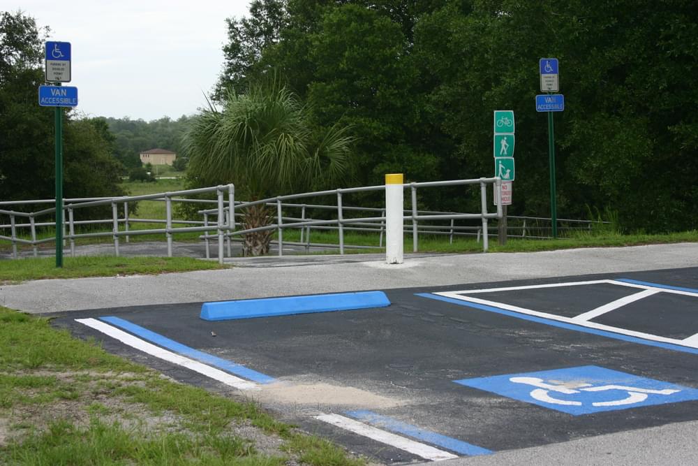 Accessible parking place with ramp in background at Citrus Springs trailhead on Withlacoochie State Trail, Florida