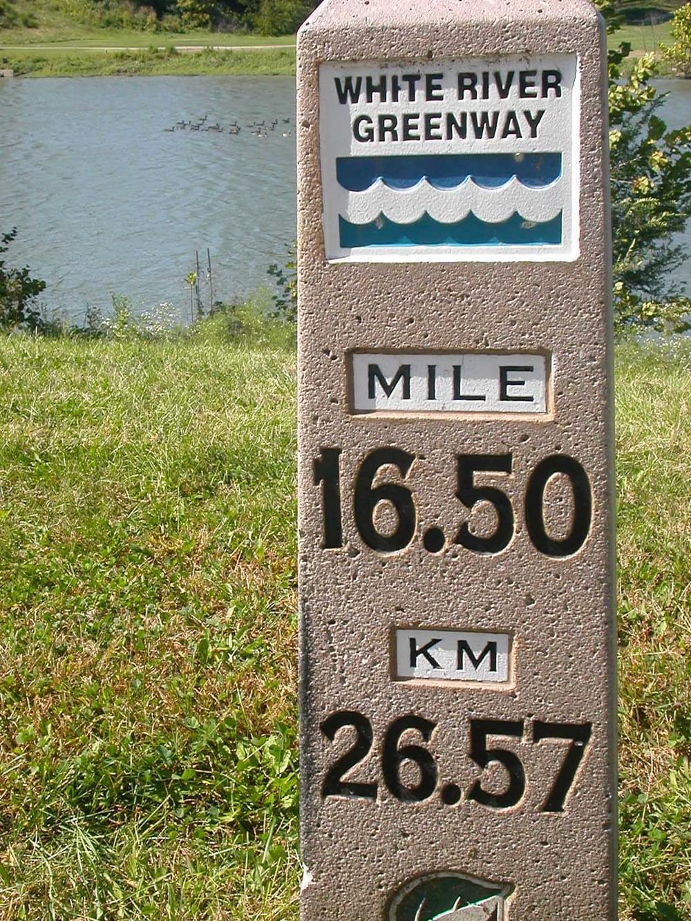 The classic concrete mile post with logo on the White River Trail; Indianapolis, Indiana