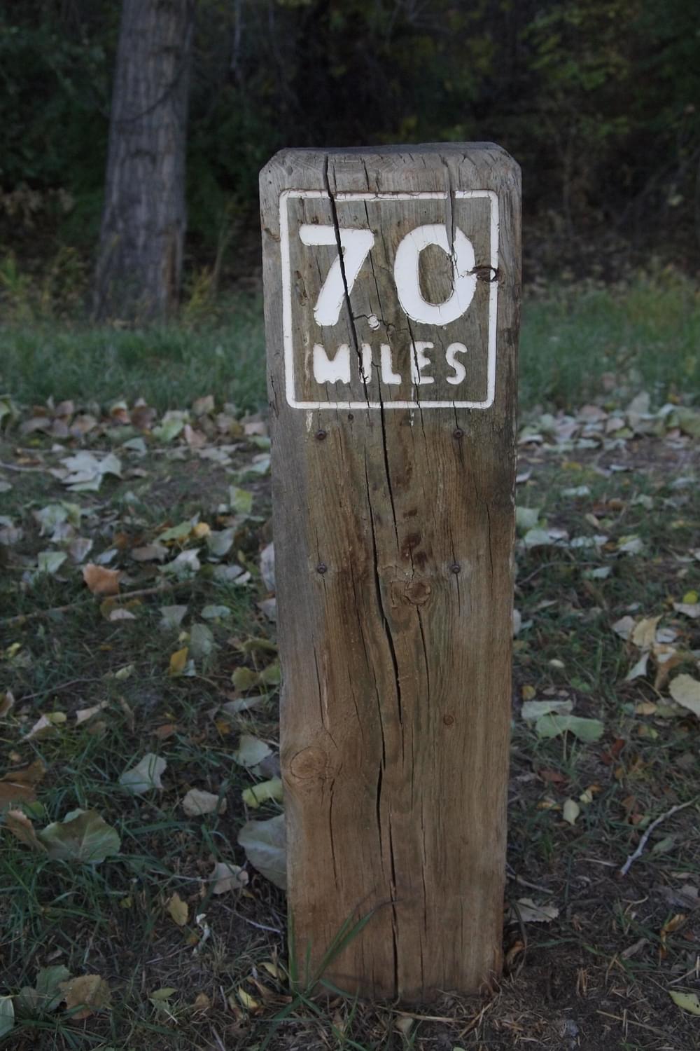 Timber mileage marker post on the Highline Canal Trail; Greenwood Village, Colorado