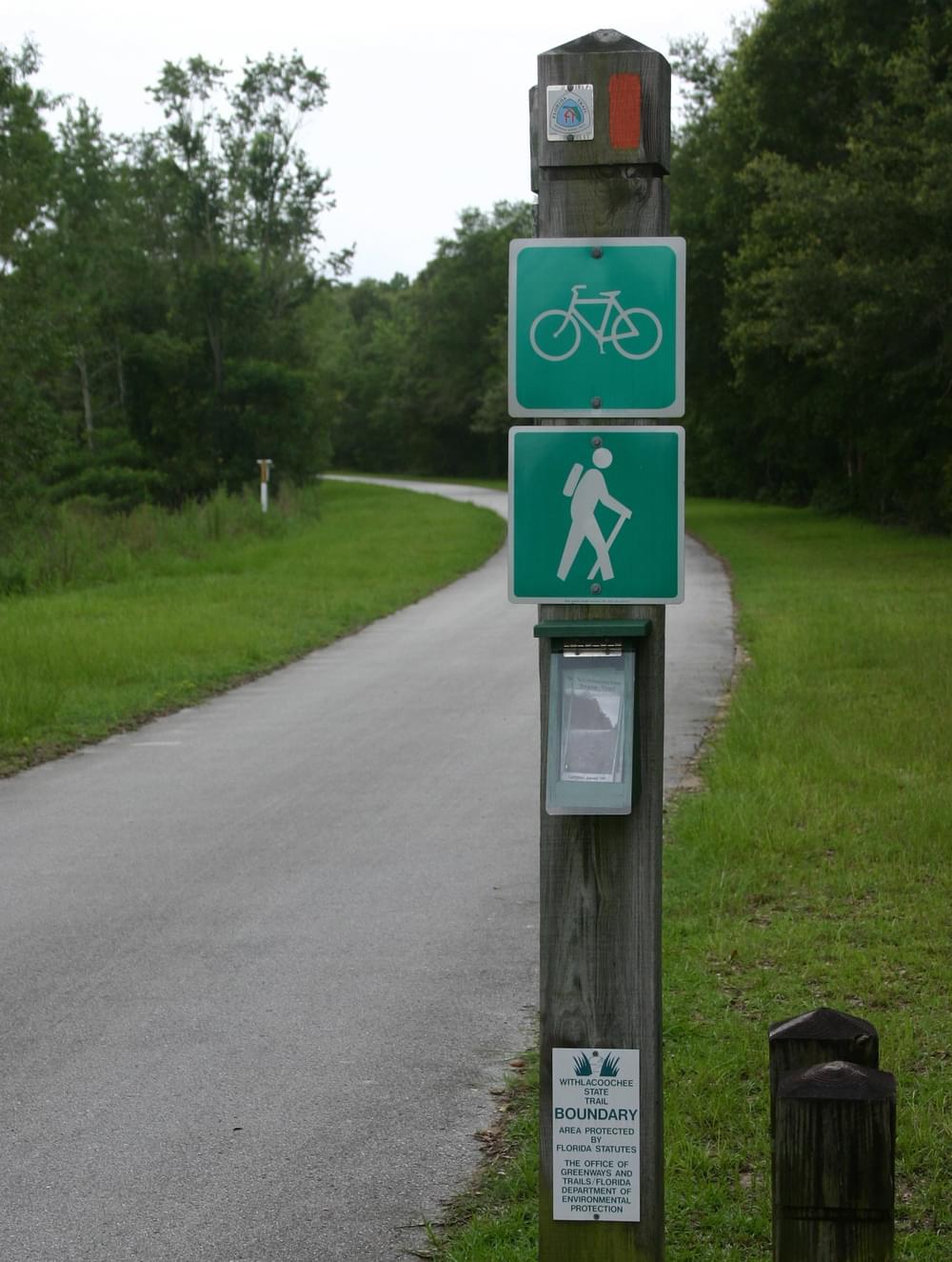 User sign with map dispenser and boundary marker on the Withlachoochie State Trail in Florida