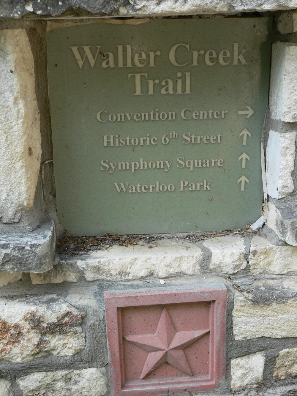 Sign for Waller Creek Trail built out of limestone with glazed ceramic sign, Austin, Texas