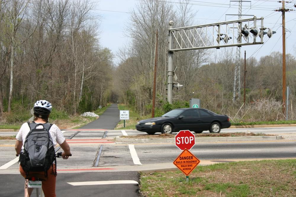 Stop sign at highway crossing but also warning about rails left in pavement on Swamp Rabbit Trail, Greenville, South Carolina