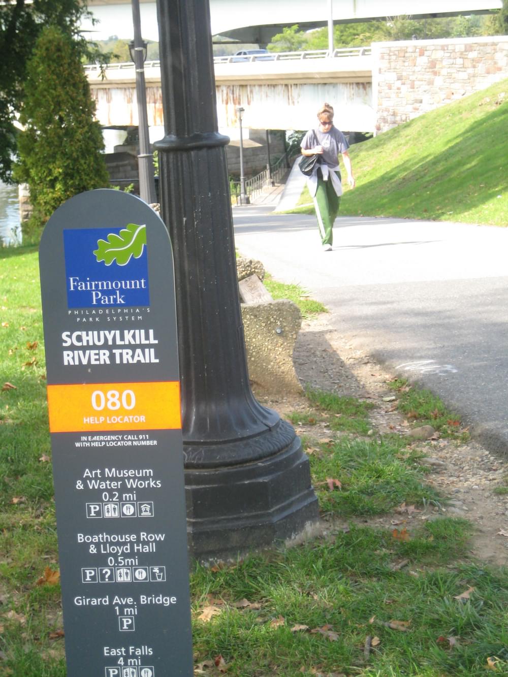 Trail signs include mileage between bridge access points on the Schuylkill River Trail; Philadelphia, Pennsylvania