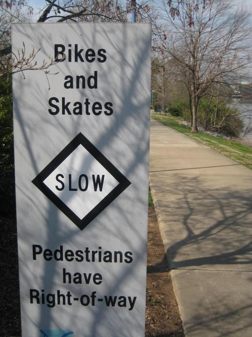 Bikers and skaters yield to walkers. Post on the Tennessee Riverwalk Trail in Chattanooga, Tennessee