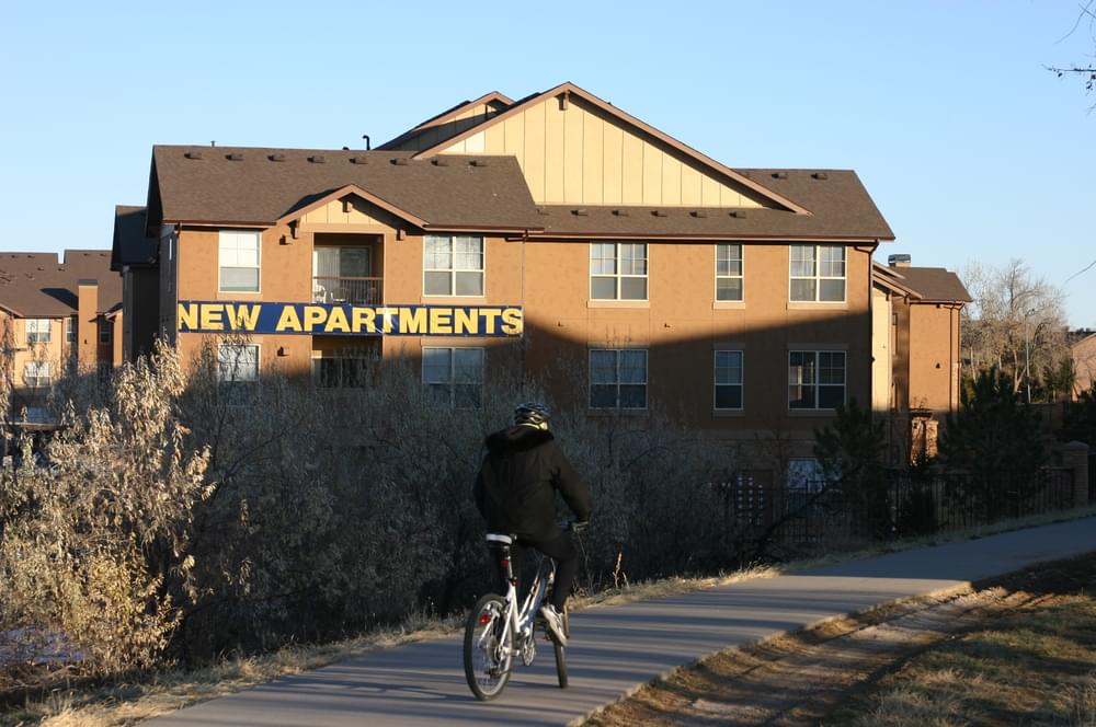 Sign advertises new apartments along the Highline Canal Trail in Aurora, Colorado