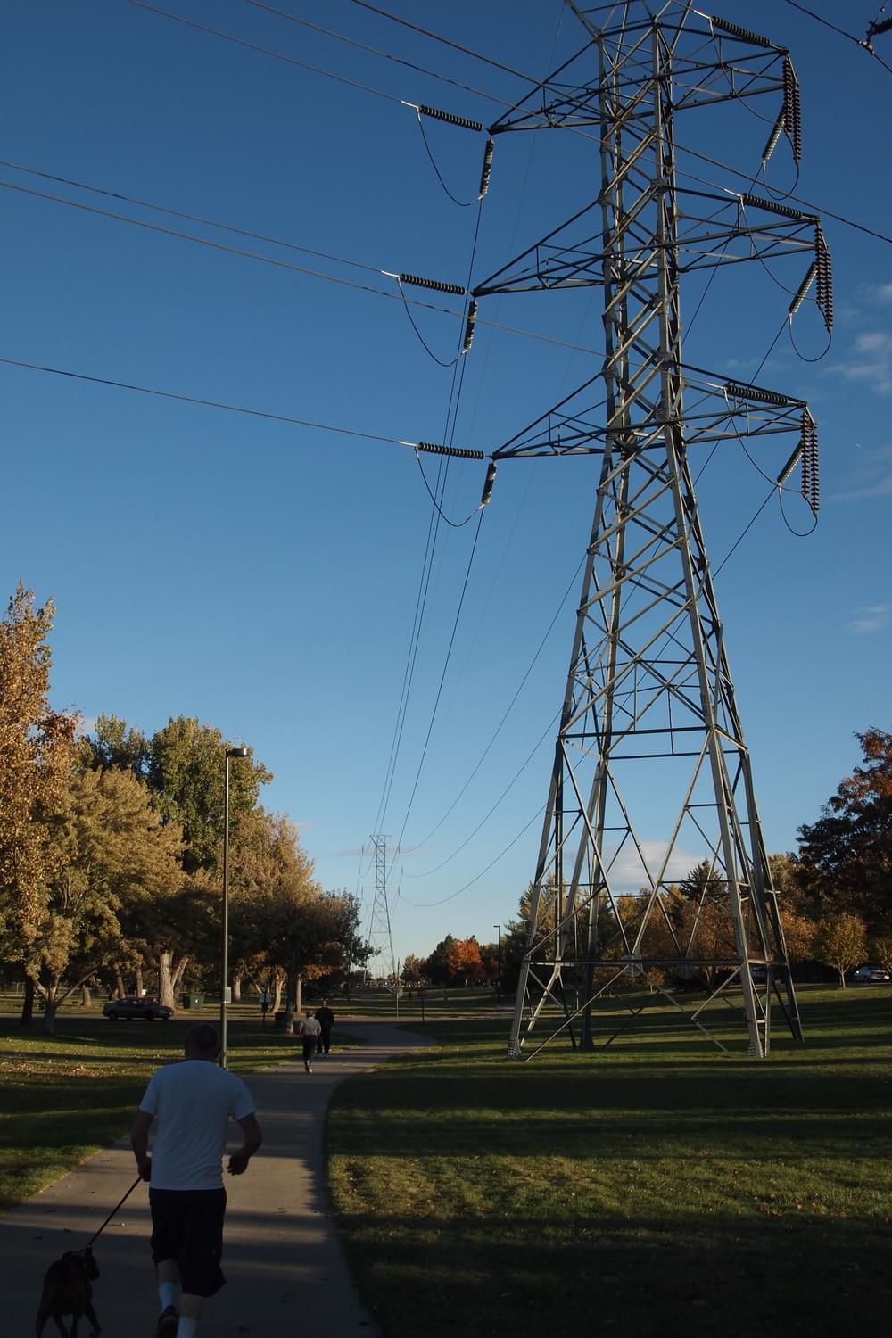Transmission structures are close to Cherry Creek Trail through park land in Denver, Colorado 