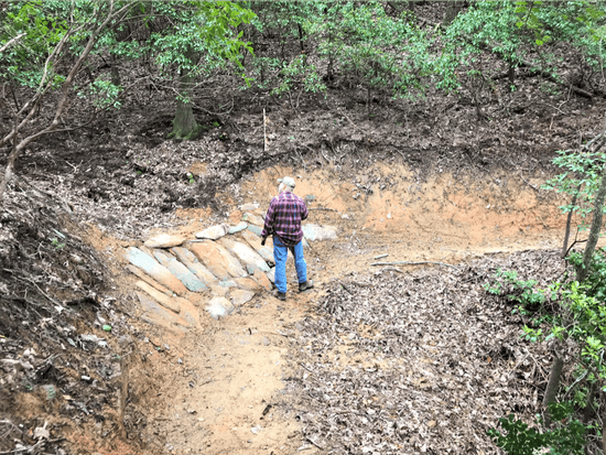 Jim Majors shows off one of the many berms Benchmark Trails constructed on the StumphousePassage.