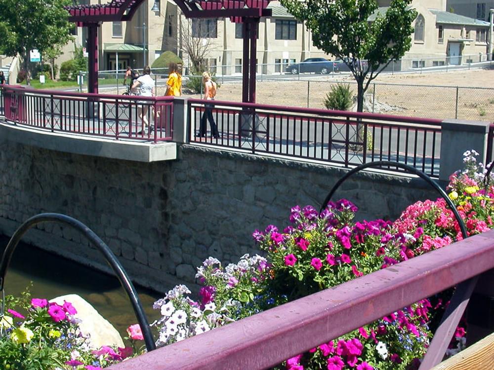 A planter on the pedestrian bridge above the Truckee River in downtown Reno, Nevada; in the background is the trail along the south side of the river with new apartments overlooking it.