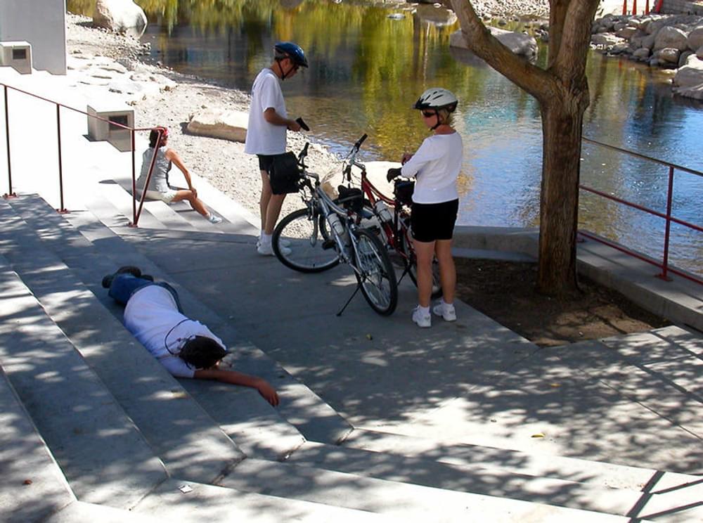 Lounging and biking along the Truckee River in downtown Reno, Nevada. A trail runs above the flood wall on each side of the river. 
