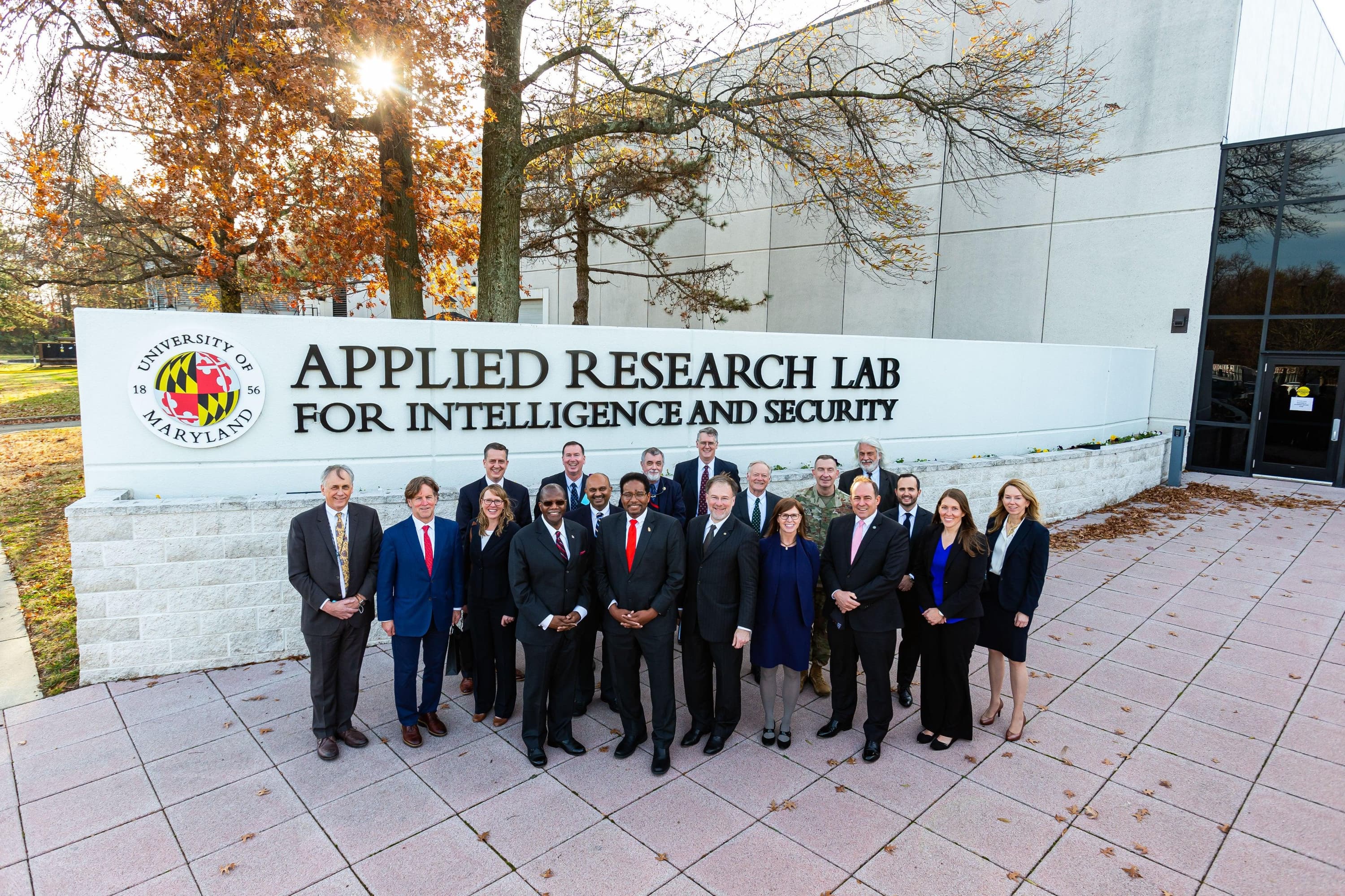 UMD and ARLIS leadership in front of the building signage.