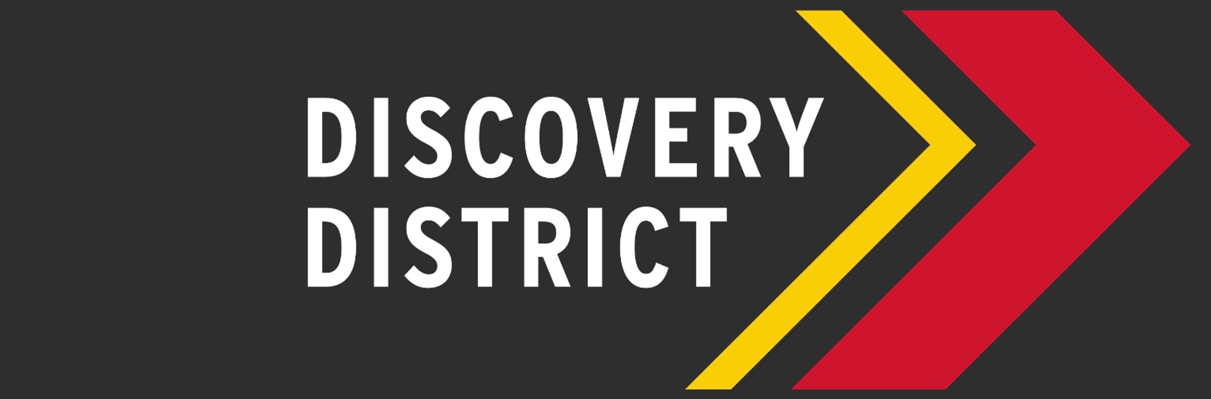Dark Grey Banner with the words Discovery District next to a yellow and red geometric arrow.
