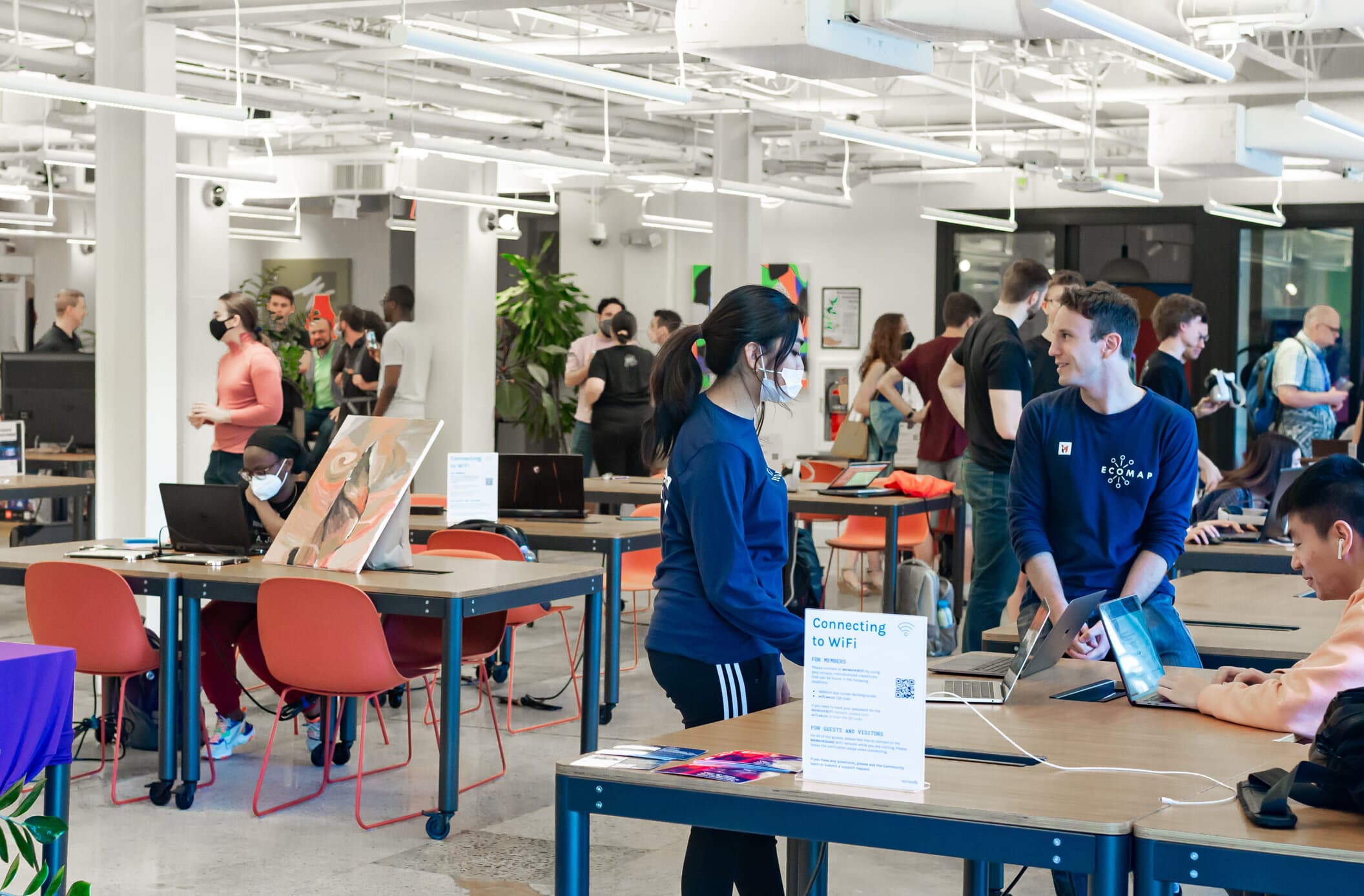 Attendees of the Innovate Maryland Art+Tech Expo visit various extended reality artists and vendors showcasing their projects within the WeWork.