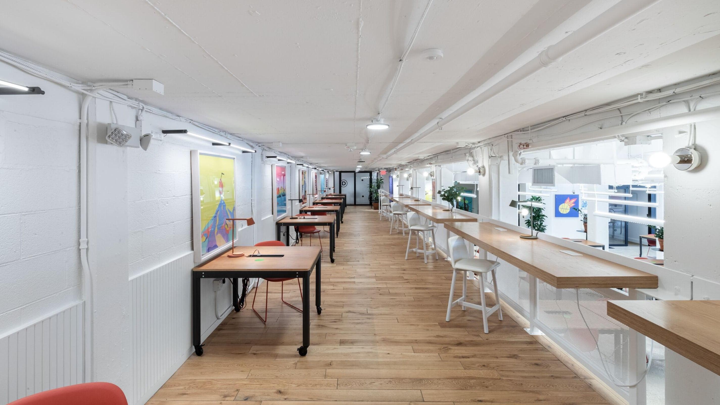 WeWork Hot Desk area. a wide mezzanine area with single person desks, and bar style work stations.