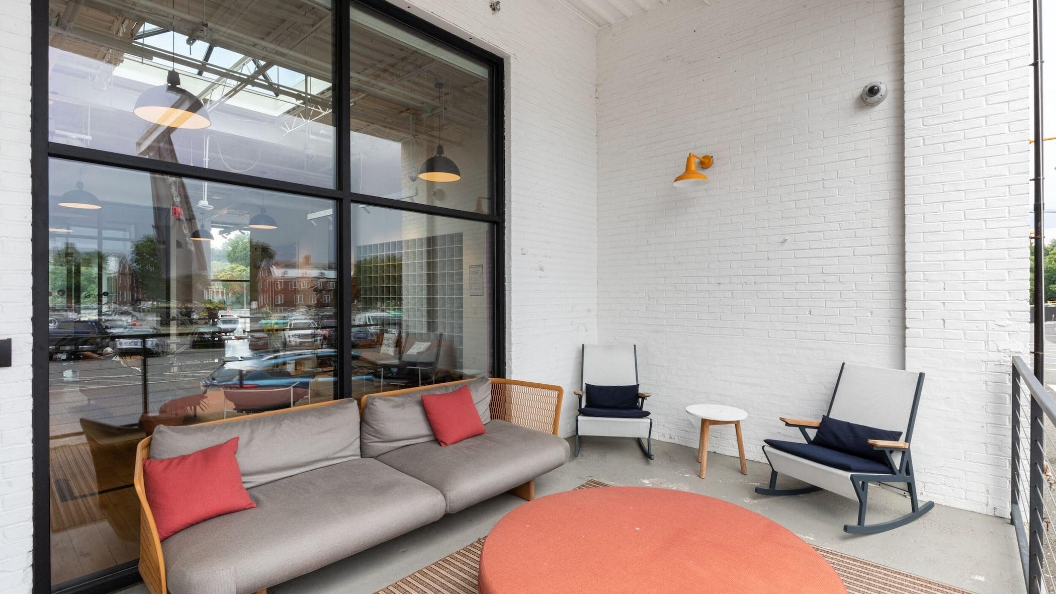 Outdoor patio space at WeWork in College Park with some cushioned bench, and individual seating
