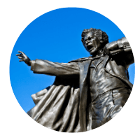 Bronze Statue of Frederick Douglass right arm out stretched and an expression of someone giving a mighty sermon