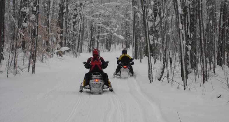 Snowmobilers enjoying fresh snow on this 200 mile trail!. Photo by cadillacmichigan.com.