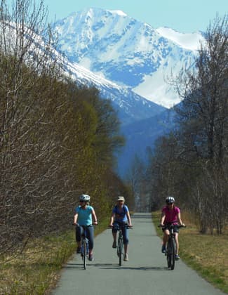 Bicyclists enoying spring sunshine on the Bird-to-Gird Trail near Anchorage. Photo by Susan Sommer.