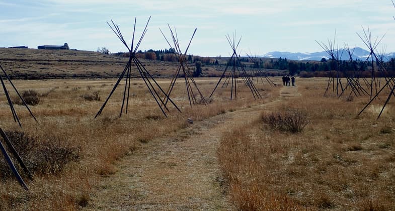 Tipi poles mark the camps of the Nez Perce during the siege.  The Park Headquarters are seen on the left. Photo by David Lingle.