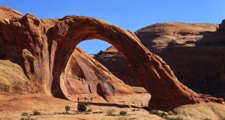 Hikers beneath Corona Arch. Photo by Valerie A. Russo. Photo by Bill Stevens