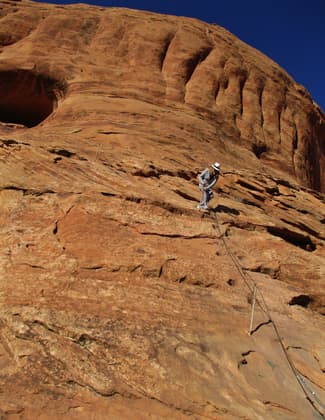 Hold onto the cable to climb or descend the steep section of slick rock. Photo by Valerie A. Russo.
