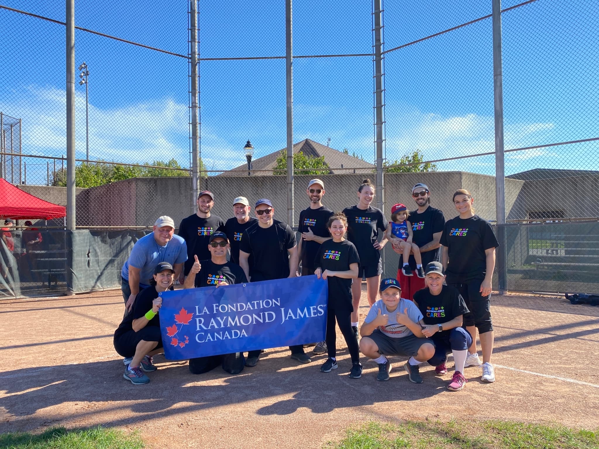 softball players posing with a banner on a field