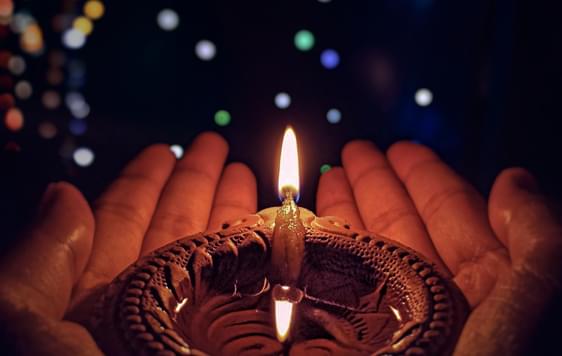 Diwali image - person holding candle in their hands