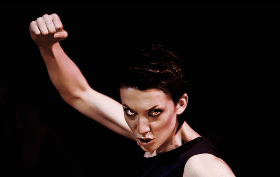 woman holding fist up in air with intense look