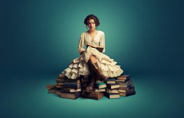 Woman sitting on a pile of books