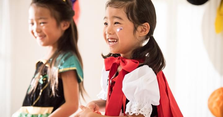 2 small children in costumes smiling