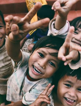 Children in dirty clothes smiling.