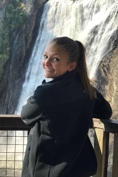 Alumna Halston Strange poses in front of a waterfall. Alumna Halston Strange poses in front of a waterfall.