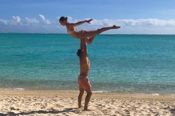 Alumna Halston Strange held up in the air above in dance pose with the ocean in the background. Alumna Halston Strange held up in the air above in dance pose with the ocean in the background.