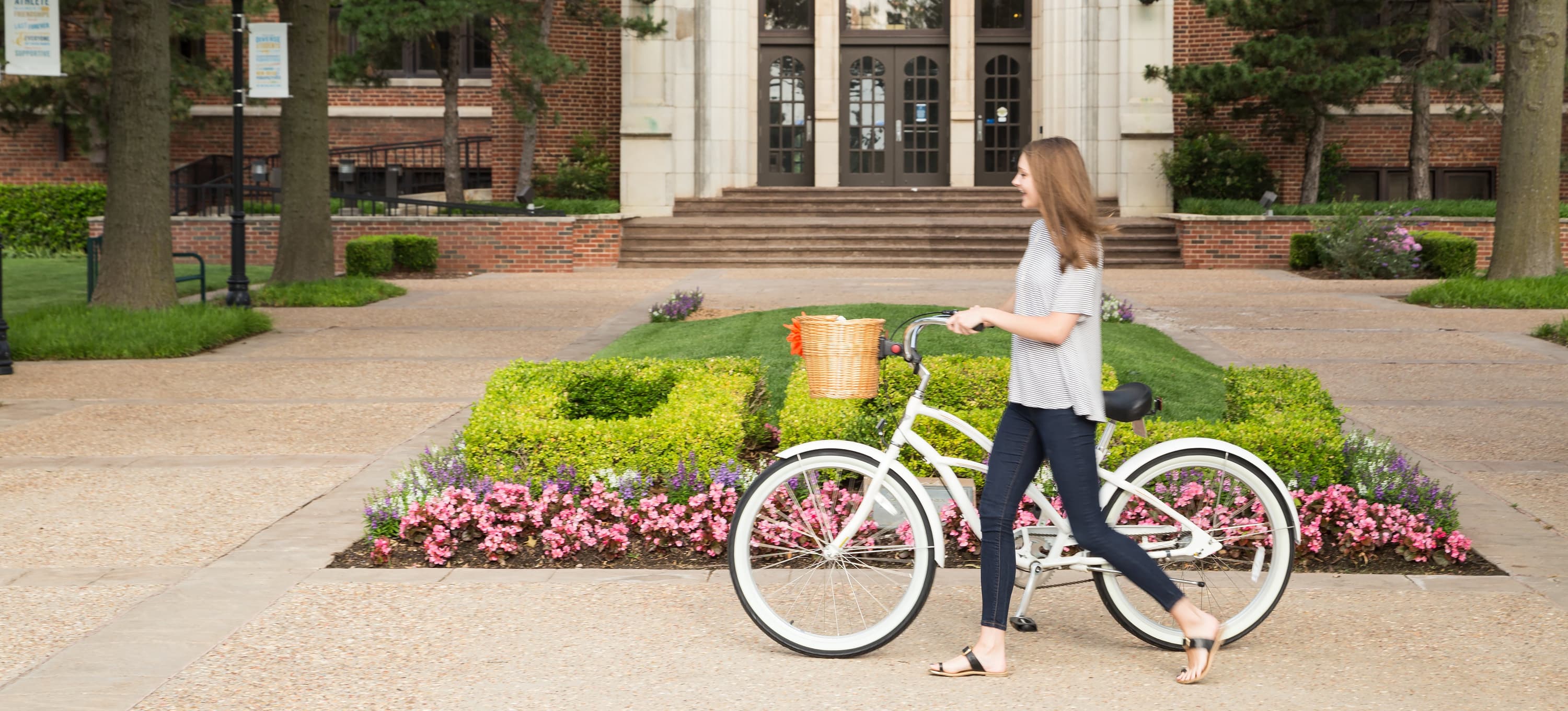 Student on bike in front of administration building