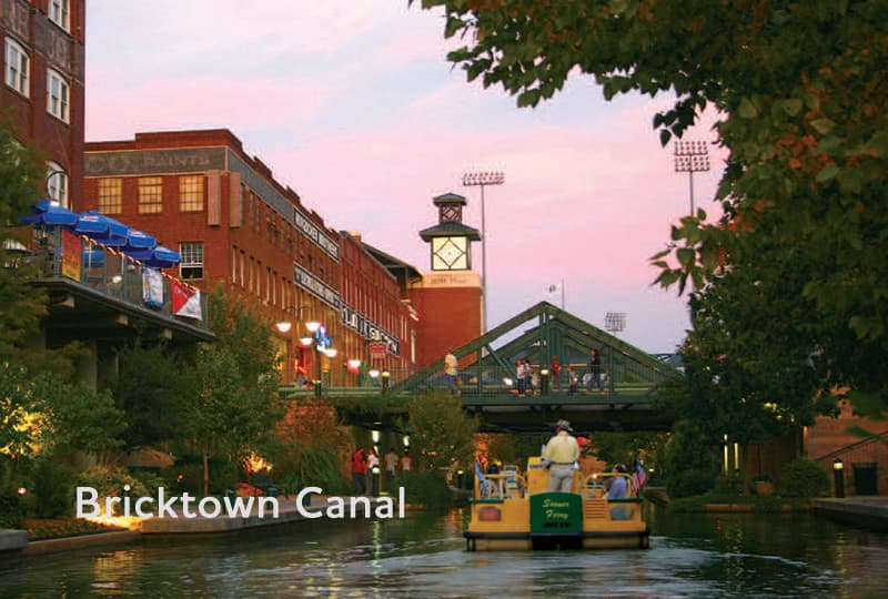 A tour boat floats past restaurants and shops on Oklahoma City's Bricktown Canal.