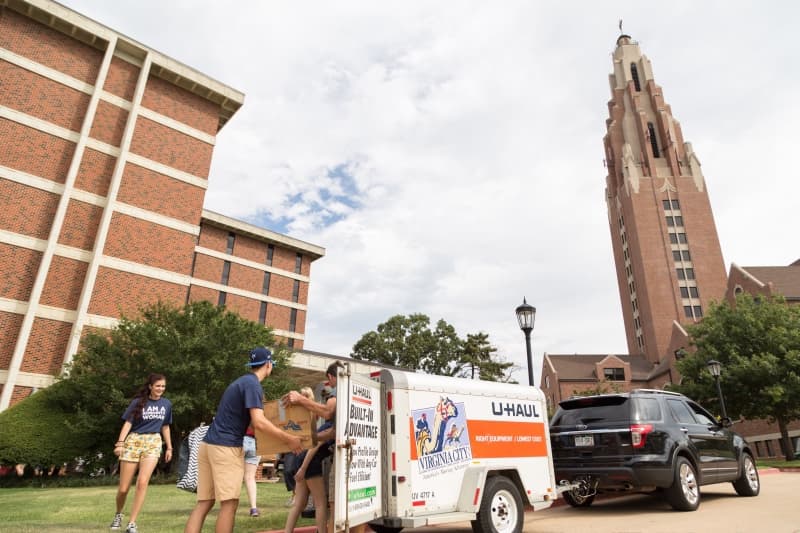 Students unload a trailer as they move in to walker hall on O C U campus