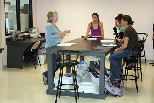 Students listen to an instructor in the Lacy Center's costume lab.