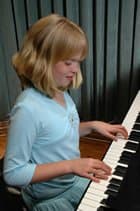 A young girl plays a piano. A young girl plays a piano.