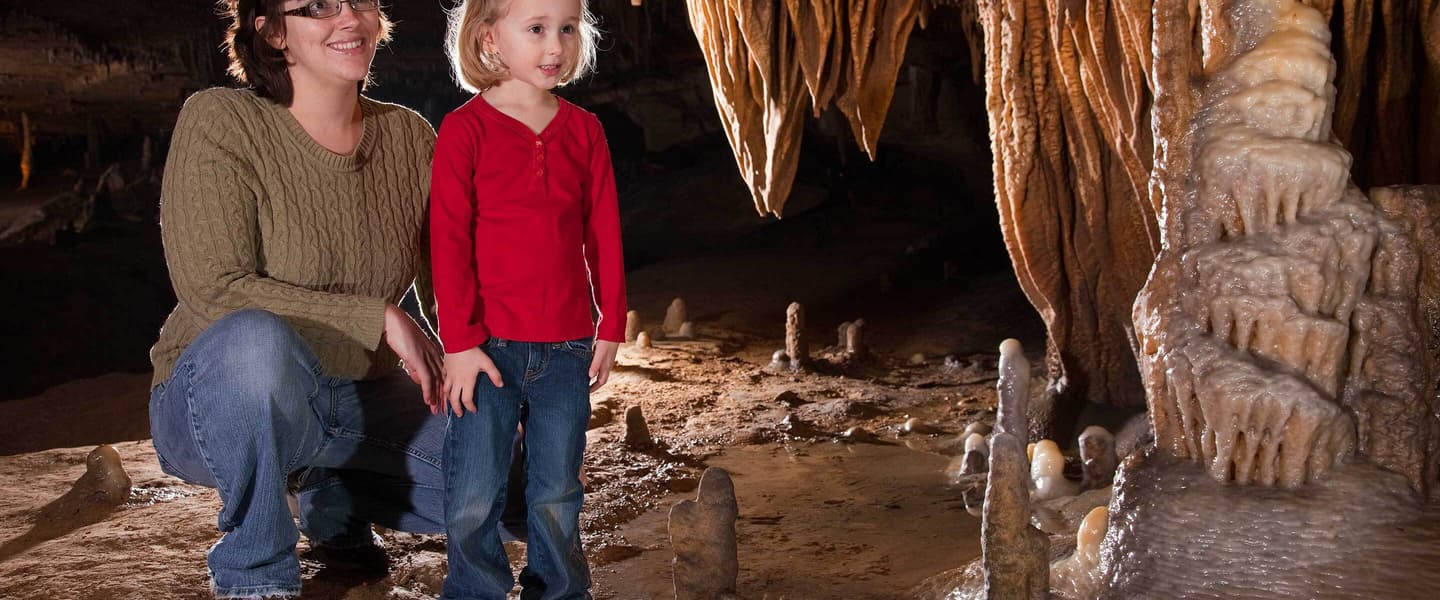 mother and daughter looking at formations in cave
