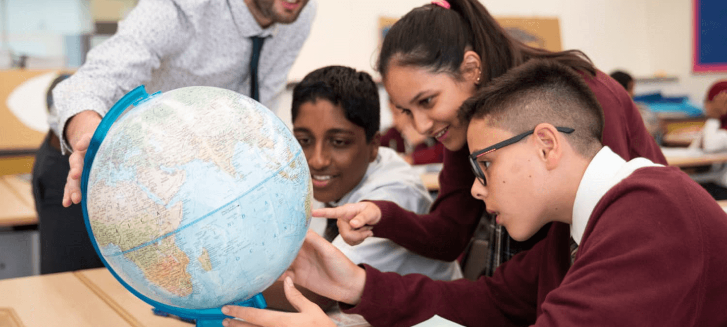 School pupils looking at a globe