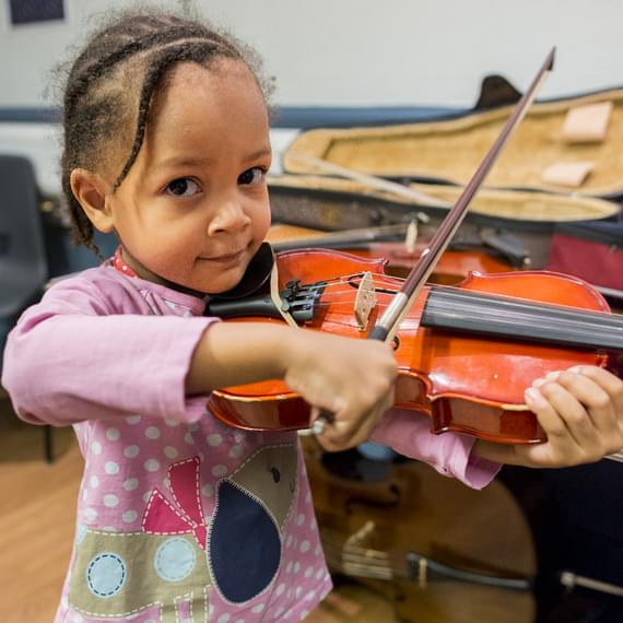 A young girl playing a violin