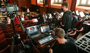 Technicians operating a sound desk and camera from the stalls of an auditiorium